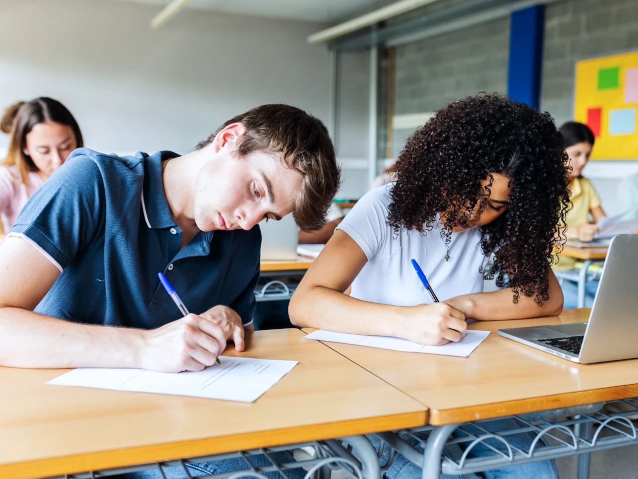 Students writing at their desks.