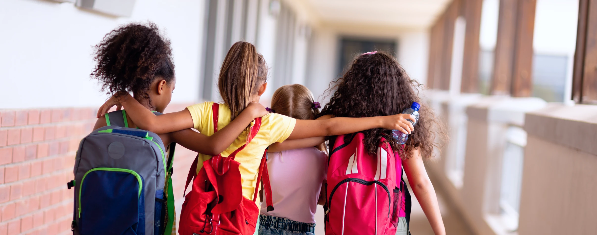 Group of students walk down a hall together.