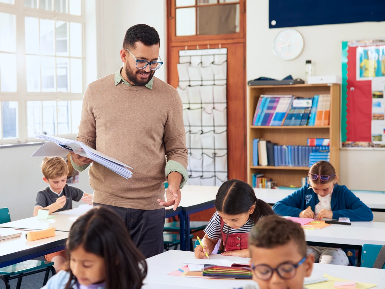 Teacher walks through classroom as students work.