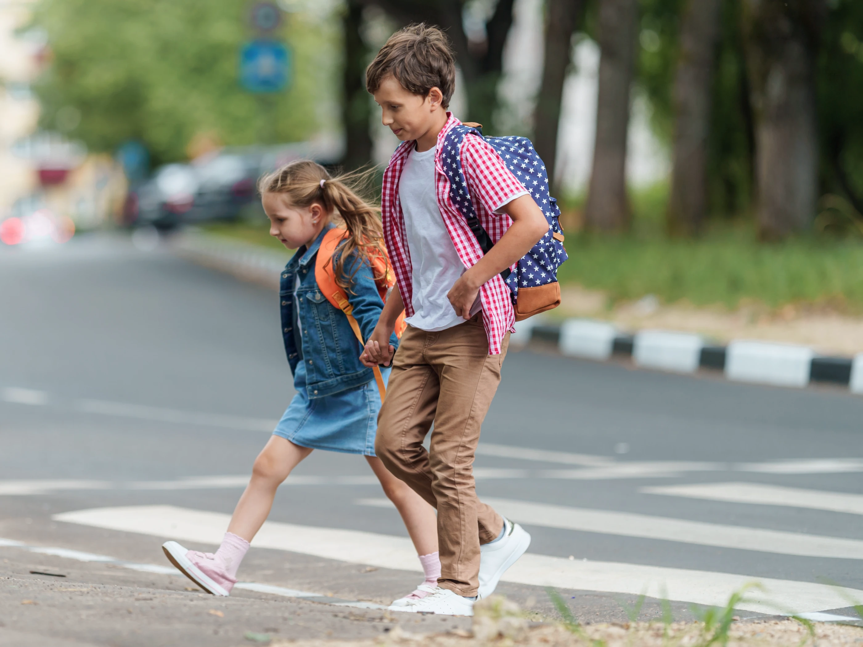 Two children crossing a street.